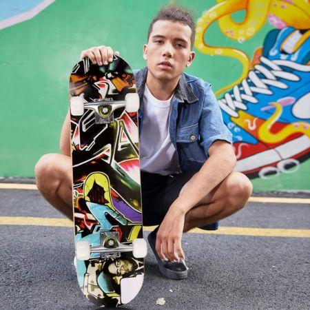 Chico agachado sosteniendo un skate Hikole Vistoso, resaltando su diseño vibrante y moderno