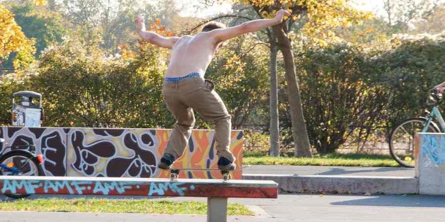skater freestyle haciendo grind en parque con graffiti